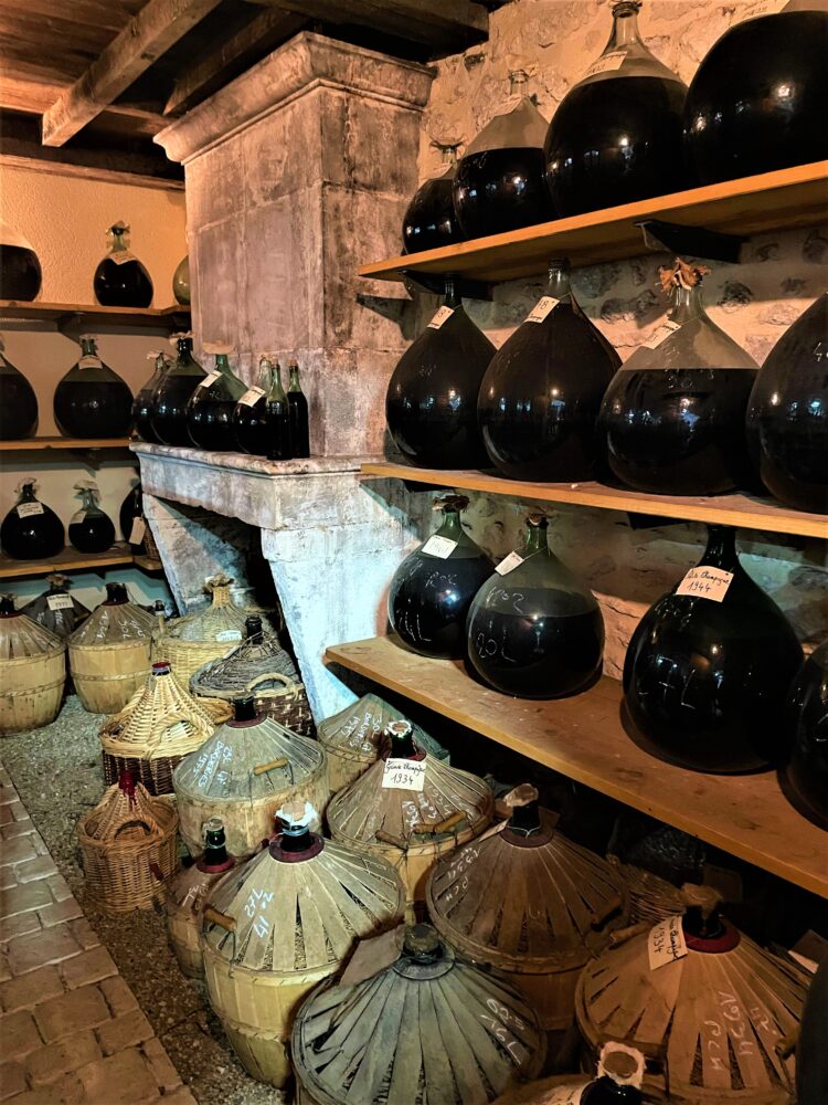 Dame-jeannes remplies de vieux Cognac dans un paradis de chai illustrant le vieillissement du Cognac