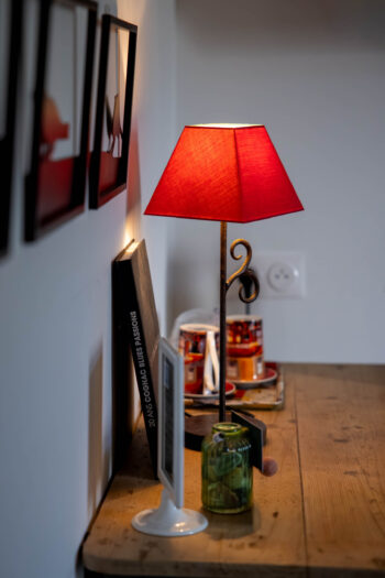 Suite Soleil Levant : bureau de travail éclairé par la lumière matinale, plateau de courtoisie, lampe de bureau et fauteuil Louis XV chiné localement